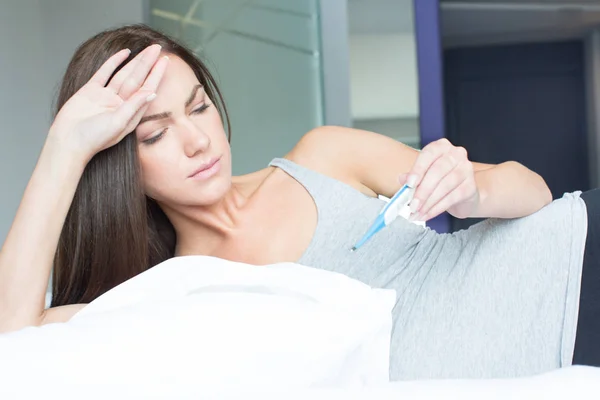 Mujer enferma midiendo la temperatura corporal — Foto de Stock