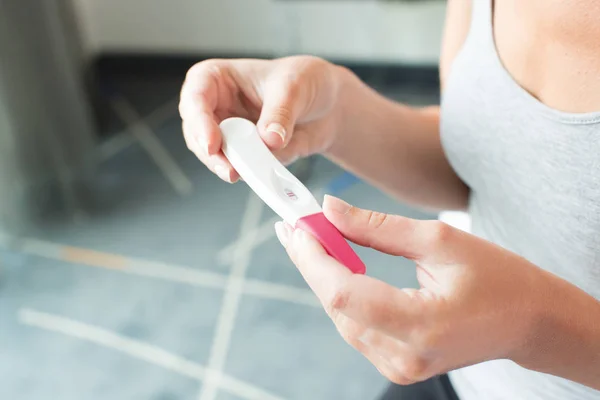 Mujer mirando una prueba de embarazo — Foto de Stock