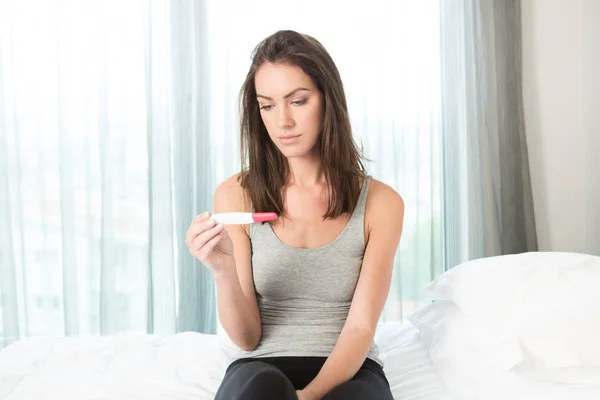 Donna che guarda un test di gravidanza — Foto Stock