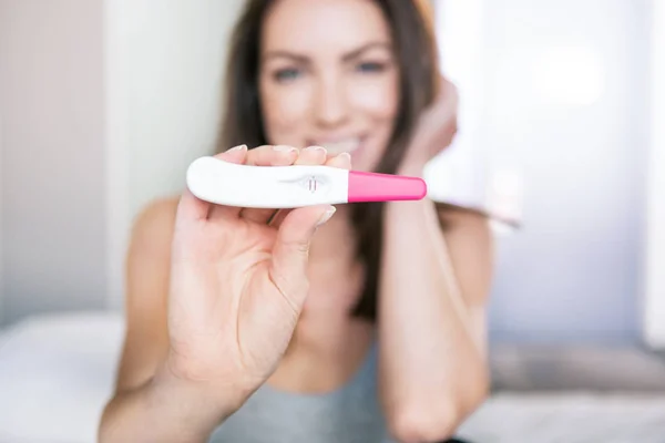 Kvinna som tittar på ett graviditetstest — Stockfoto