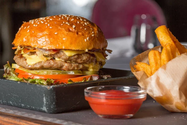 Dubbele hamburger met frietjes geserveerd — Stockfoto