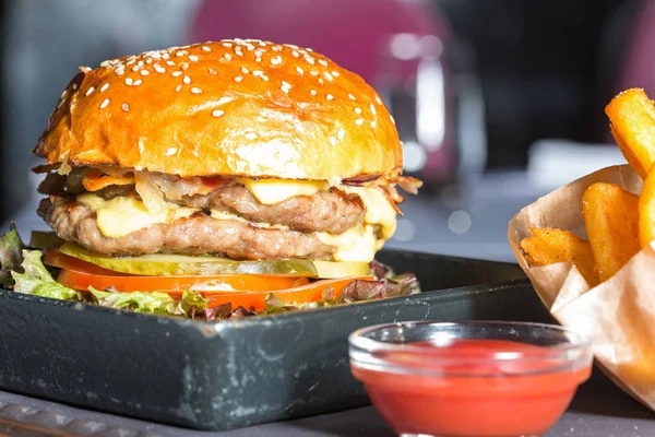 Dubbele hamburger met frietjes geserveerd — Stockfoto
