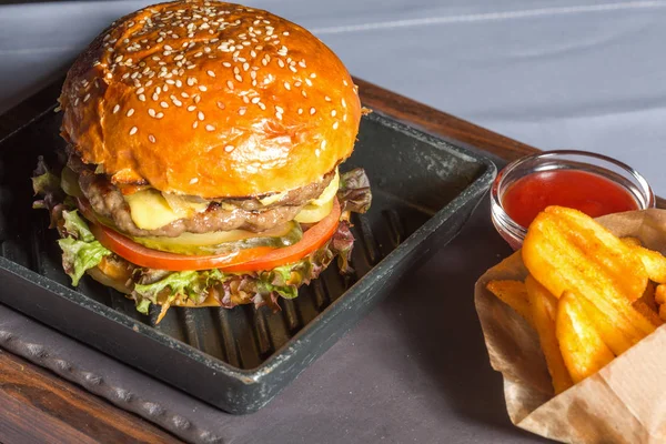 Dubbele hamburger met frietjes geserveerd — Stockfoto