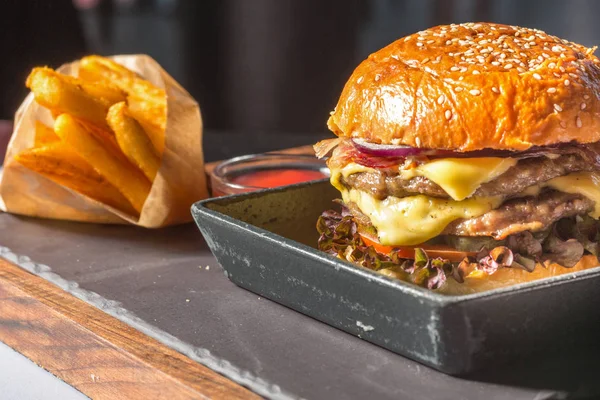 Dubbele hamburger met frietjes geserveerd — Stockfoto