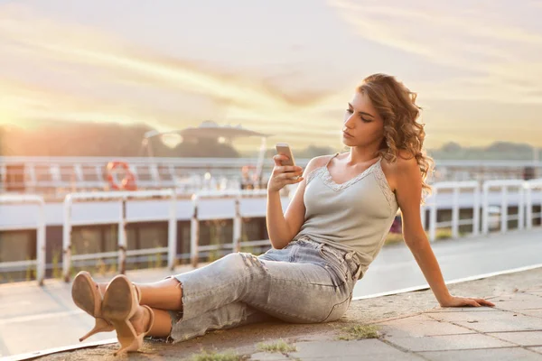 携帯電話で川沿い橋の上、かなり若い女性 — ストック写真