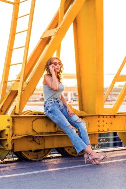 genç, güzel kadın cep telefonu ile nehir köprüsü