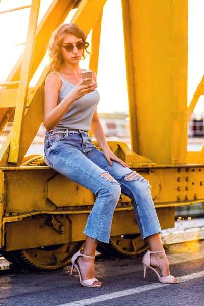 genç, güzel kadın cep telefonu ile nehir köprüsü