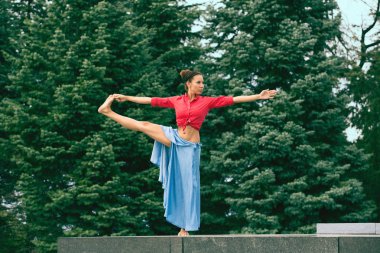 Güzel genç kadın çalışma dışarı, yoga egzersiz yaparak