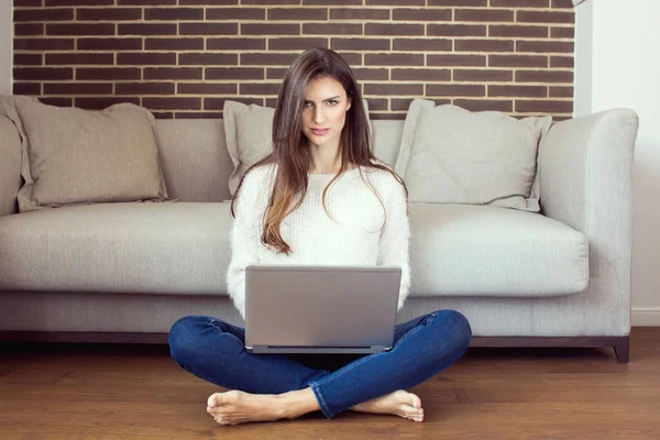 Young woman relaxing at home with a laptop