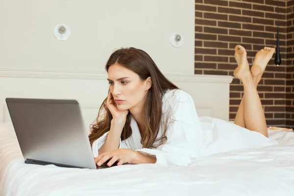 Young woman relaxing at home with a laptop