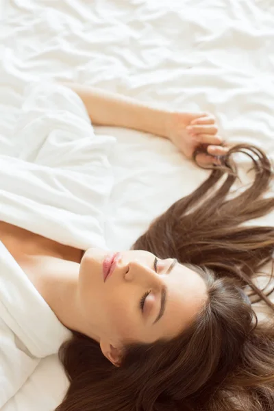 Молодая женщина в постели расслабляющий — стоковое фото
