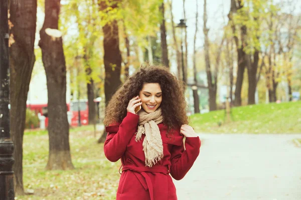 휴대 전화와 빨간 자 켓에 아름 다운 여자 — 스톡 사진