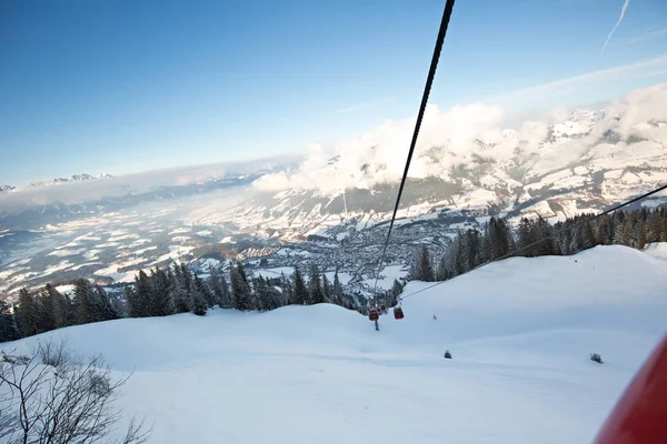 Red gondola car lift on the ski resort over forest trees