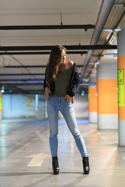 Mooie jonge brunette met lange haren poseren in een parking gara — Stockfoto
