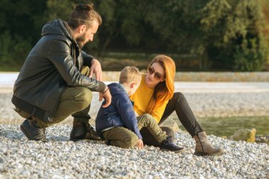 Plajda çocuk ile sonbaharda Çift