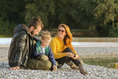 Plajda çocuk ile sonbaharda Çift