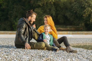 Plajda çocuk ile sonbaharda Çift