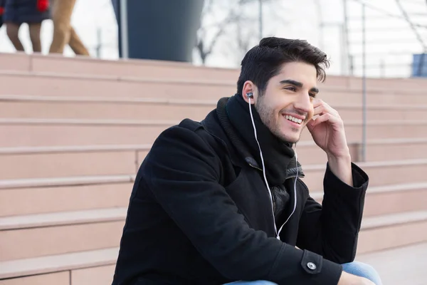 Jonge man met slimme telefoon op stad straat in de winter — Stockfoto