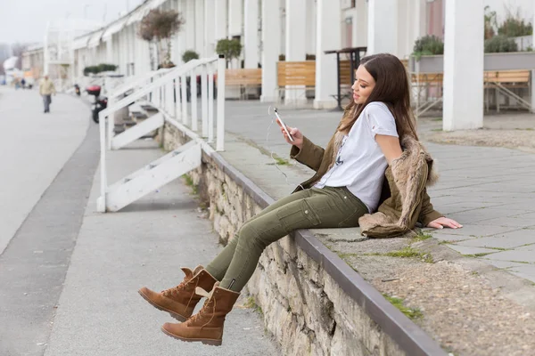Junge Frau mit ihrem Handy beschäftigt — Stockfoto