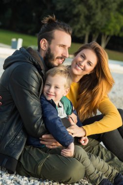 Plajda çocuk ile sonbaharda Çift