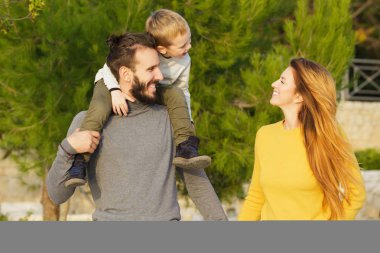 Mutlu bir aile sonbahar parkta yürüyor