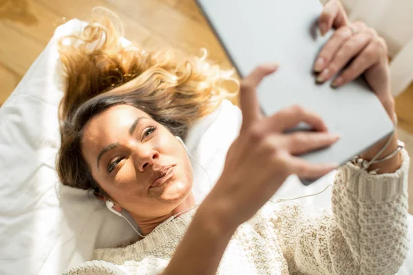 Giovane donna che prende selfie nel letto d'albergo — Foto Stock