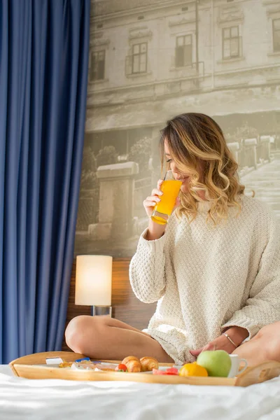 호텔 침대에서 아침을 먹는 매력적 인 여성 — 스톡 사진