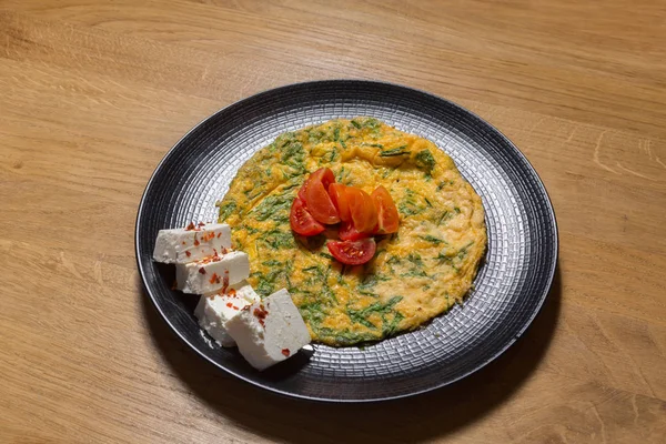 Egg omelet served on black plate — Stock Photo, Image
