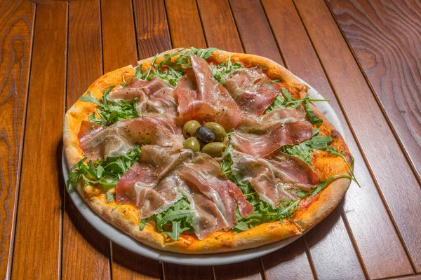 Arugula prosciutto pizza podawana na talerzu w restauracji — Zdjęcie stockowe