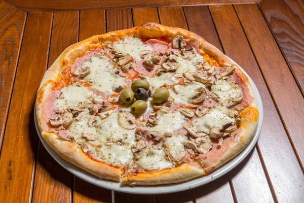 Capricciosa pizza served on a plate in the restaurant — Stock Photo, Image