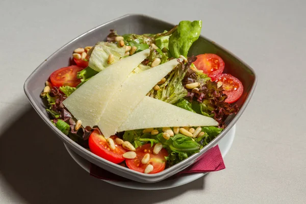 Salada verde mista com queijo parmesão em uma tigela — Fotografia de Stock
