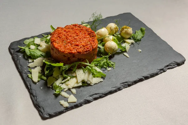 Steak tartare served on black stone — Stock Photo, Image