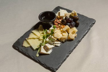 Peynirli siyah taş tahtada zeytin fıstığı