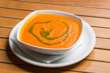 Restoranda beyaz tabakta servis edilen kabak çorbası.