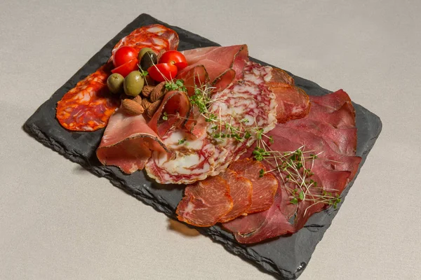 Various salami served on black stone — Stock Photo, Image