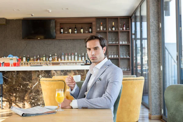 젊고 잘생긴 사업가 가 호텔 카페에서 커피를 마시고 있습니다 — 스톡 사진