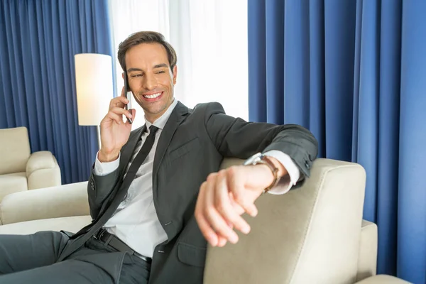 Empresário falando no celular em seu quarto de hotel — Fotografia de Stock