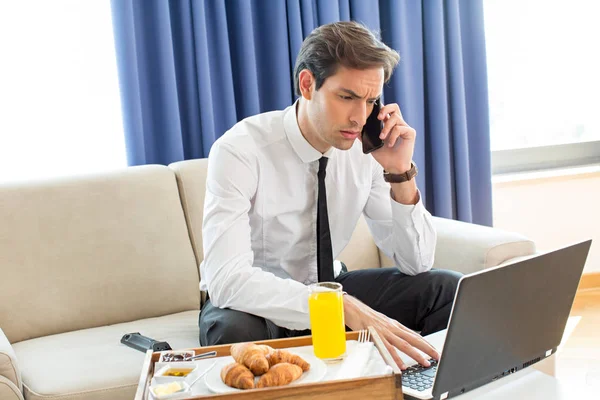 Uomo d'affari che parla al cellulare nella sua stanza d'albergo — Foto Stock