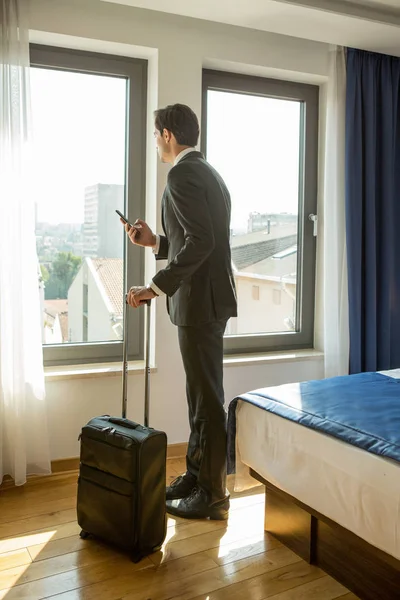 Businessman, pilot, looking through a hotel room window