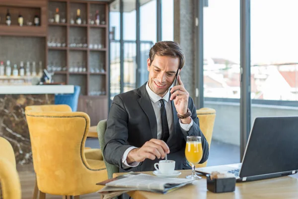 Knappe jonge zakenman praat op de mobiele telefoon in hotel c — Stockfoto