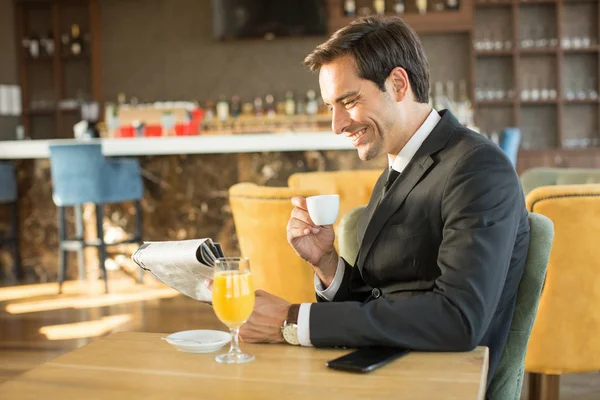 新聞を読んでコーヒーを飲むハンサムな若いビジネスマン — ストック写真