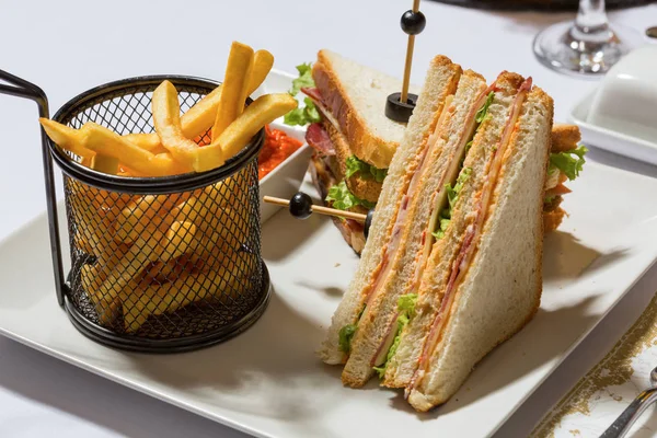 Clubsandwich geserveerd op wit bord in het restaurant — Stockfoto