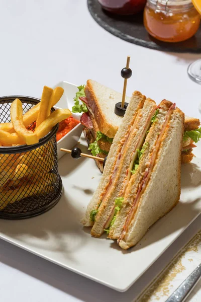 Clubsandwich geserveerd op wit bord in het restaurant — Stockfoto