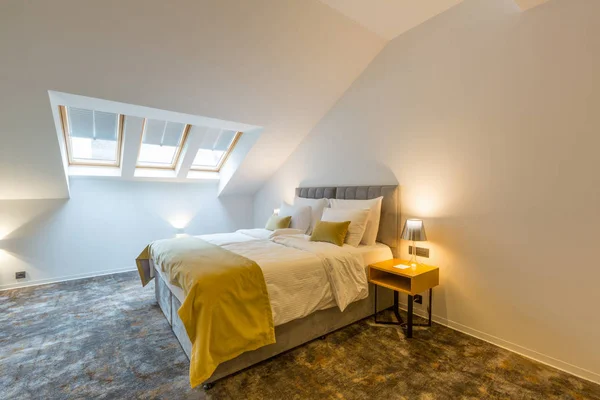 Interiér podkrovní ložnice s manželskou postelí — Stock fotografie