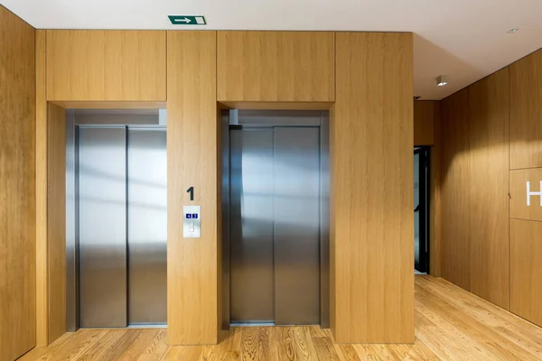 Wnętrze drewnianych ścian hotelowy korytarz z drzwiami windy — Zdjęcie stockowe