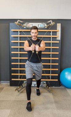 Spor salonunda tam vücut kablo makarası çalışması.