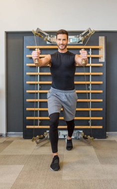 Spor salonunda tam vücut kablo makarası çalışması.