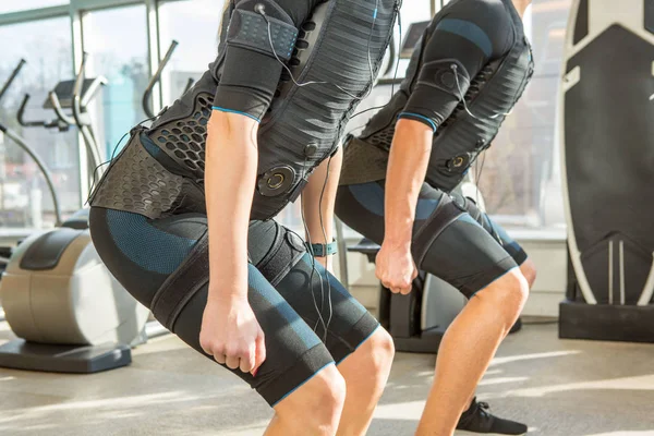 Uomo e donna che fanno elettrostimolazione muscolare formazione in un m — Foto Stock