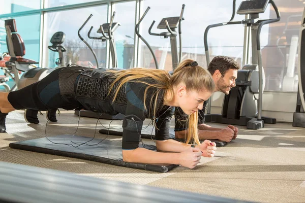 Man and woman doing electro muscular stimulation training in a m