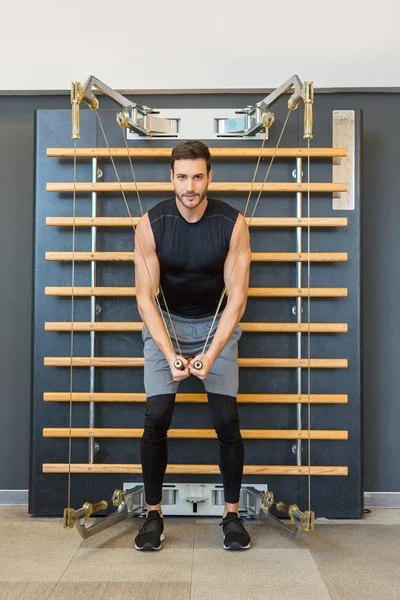 Entrenamiento de la máquina de polea de cable de cuerpo completo en el gimnasio — Foto de Stock